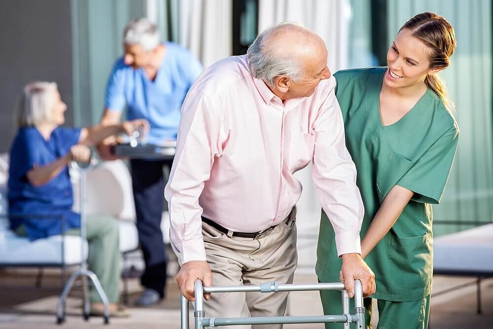 Pielęgniarka pomaga starszej osobie w domu seniora